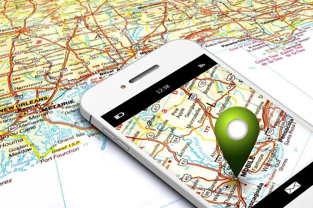 mobile phone with gps laying on map background